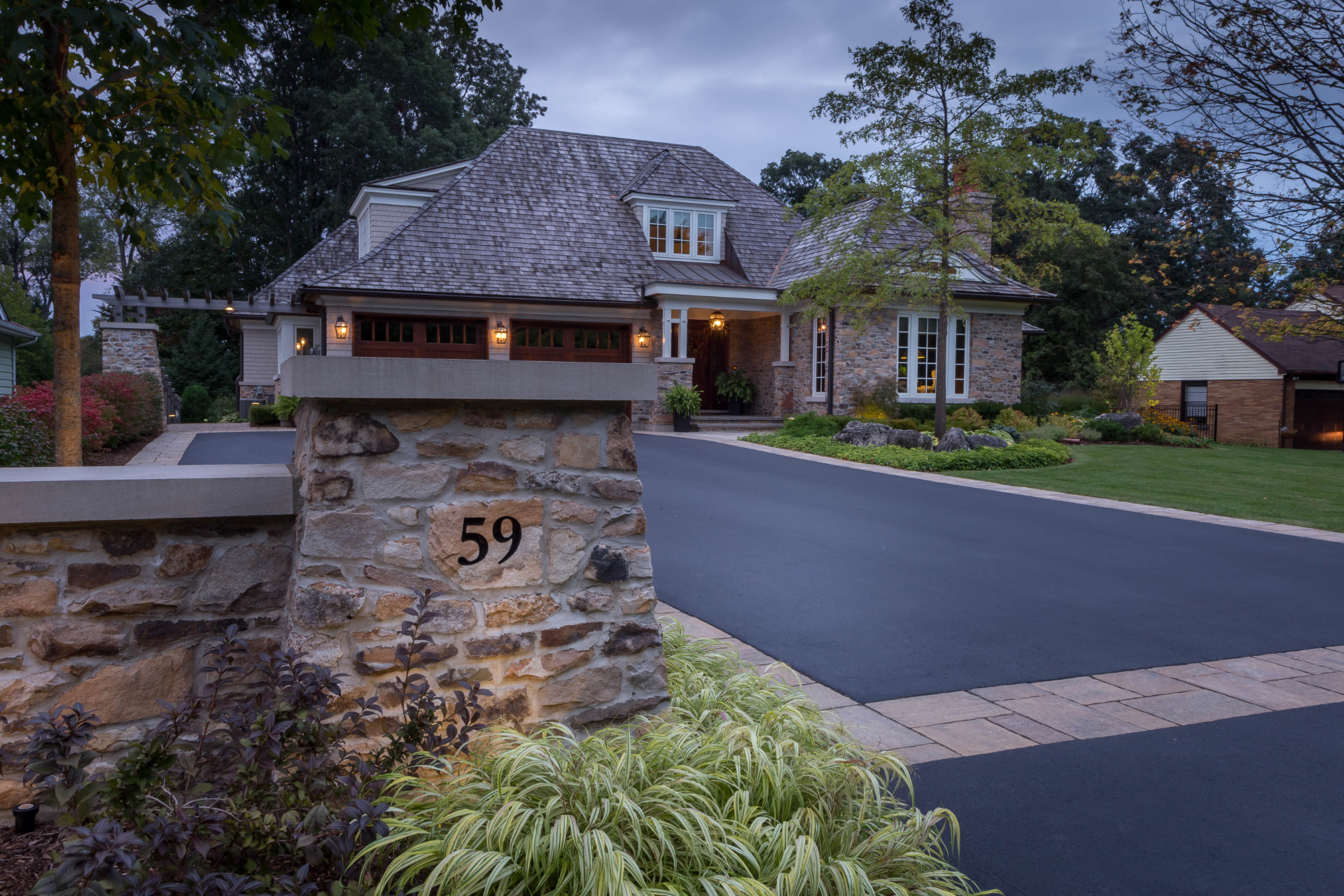 Natural stone entrance pillars and wall with paver banding