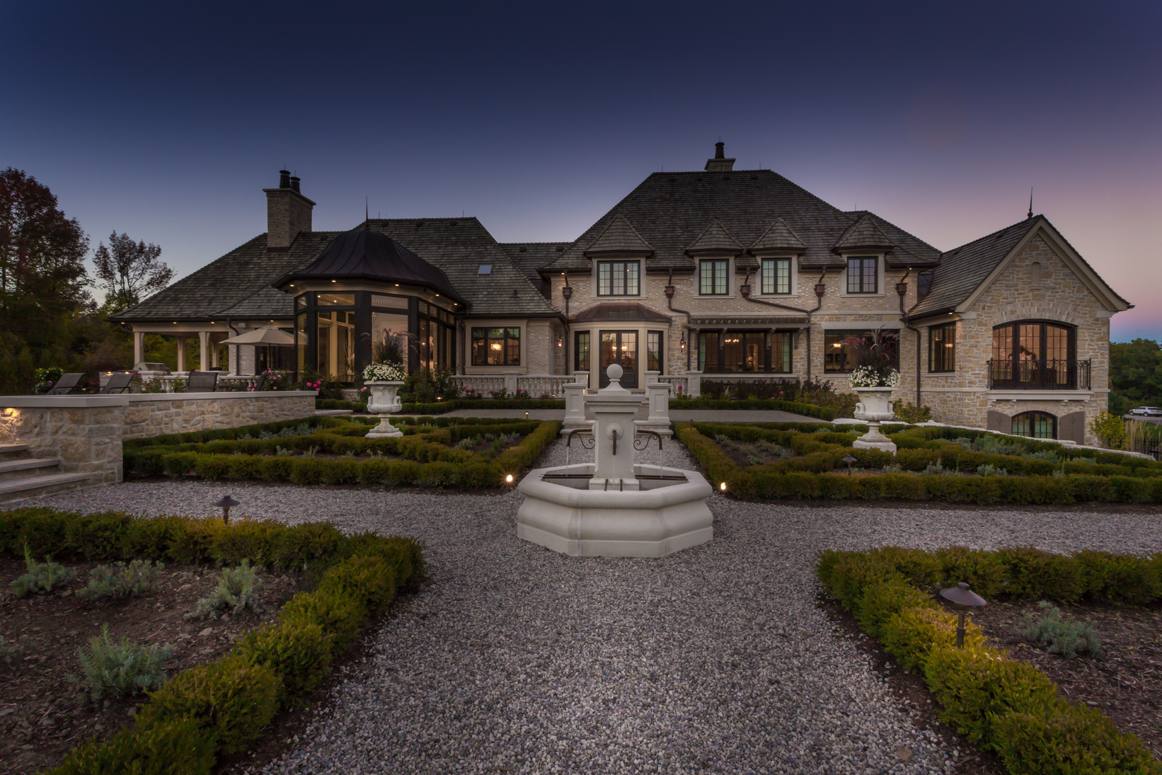 Formal estate fountain with parterre gardens at twilight