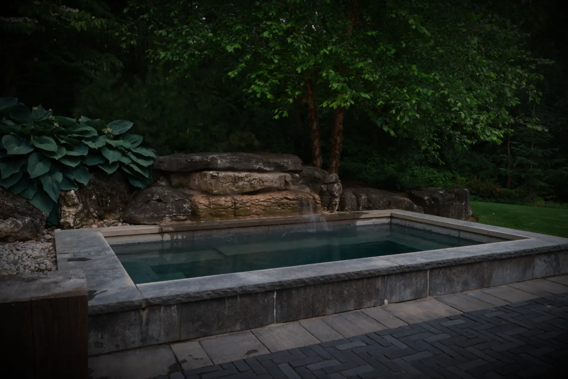 Stone-edged spa with natural rock waterfall