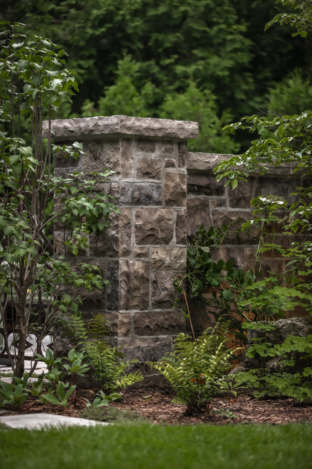 Natural stone pillar and garden wall with flagstone steppers