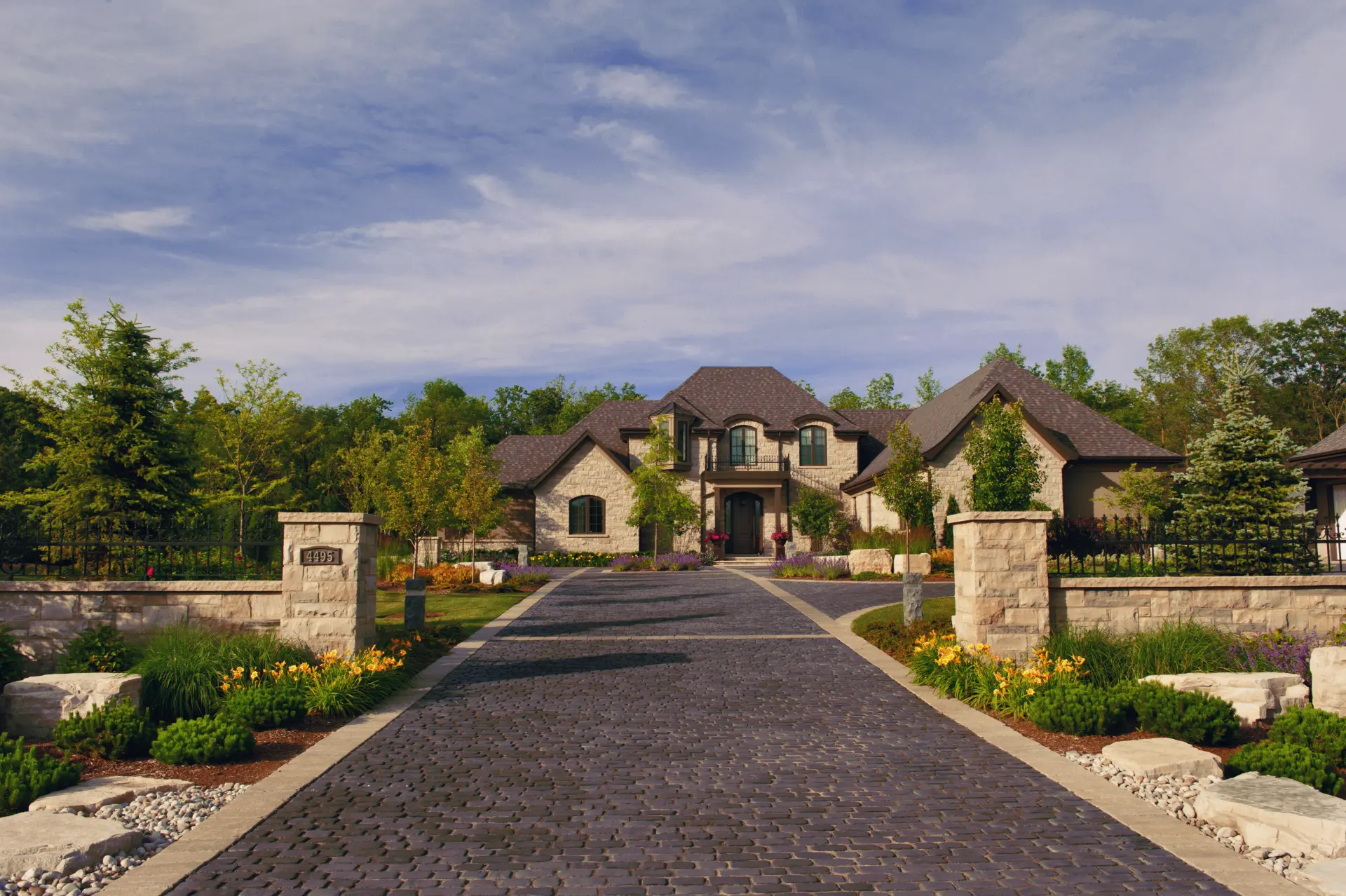 Grand paver driveway with stone pillars