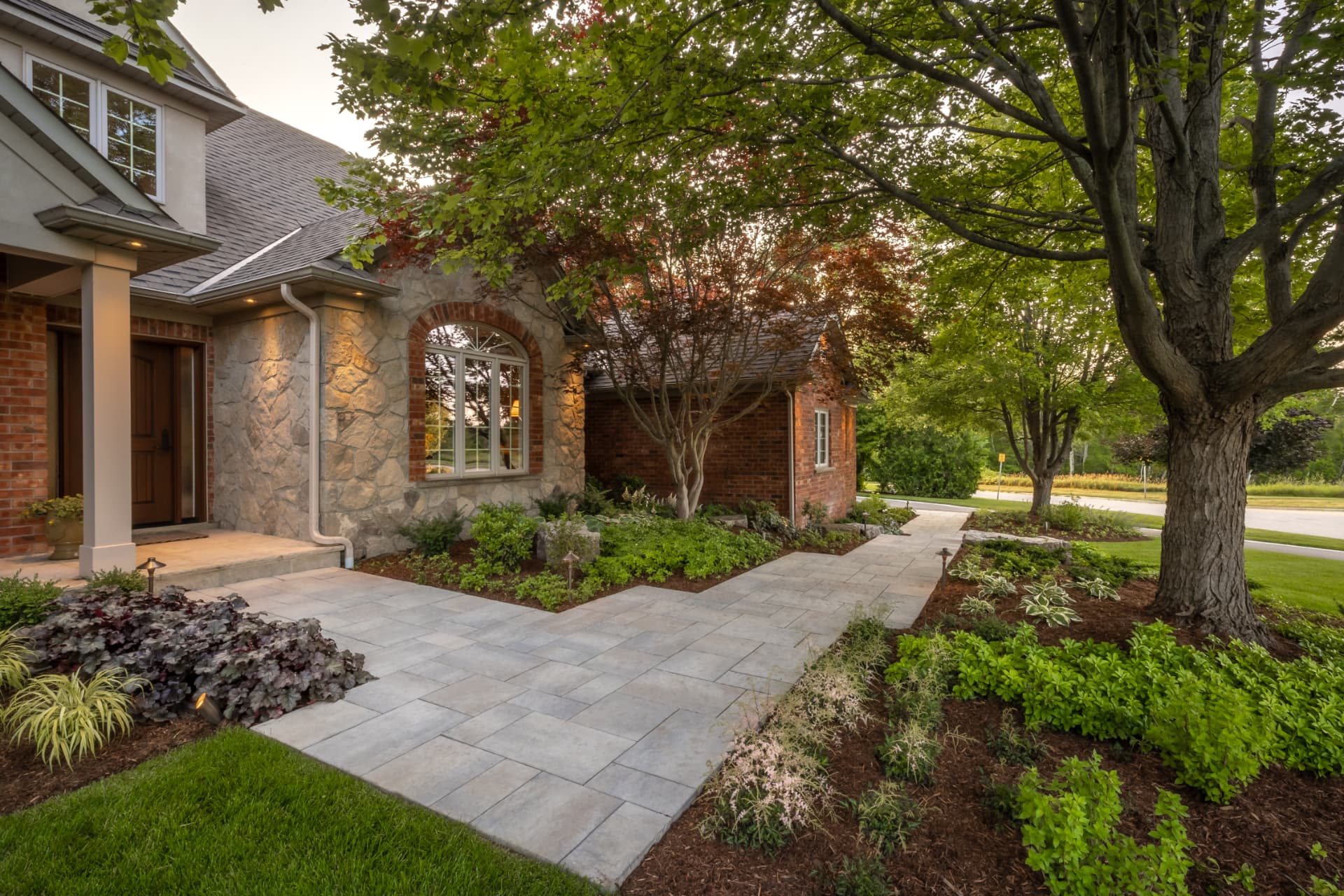 Paver front entry walkway through layered garden beds
