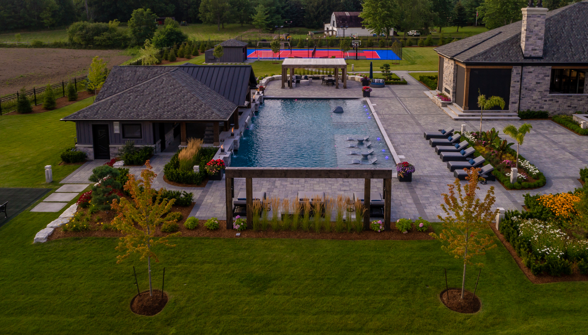 Aerial view of an estate pool with pavilion and sport court
