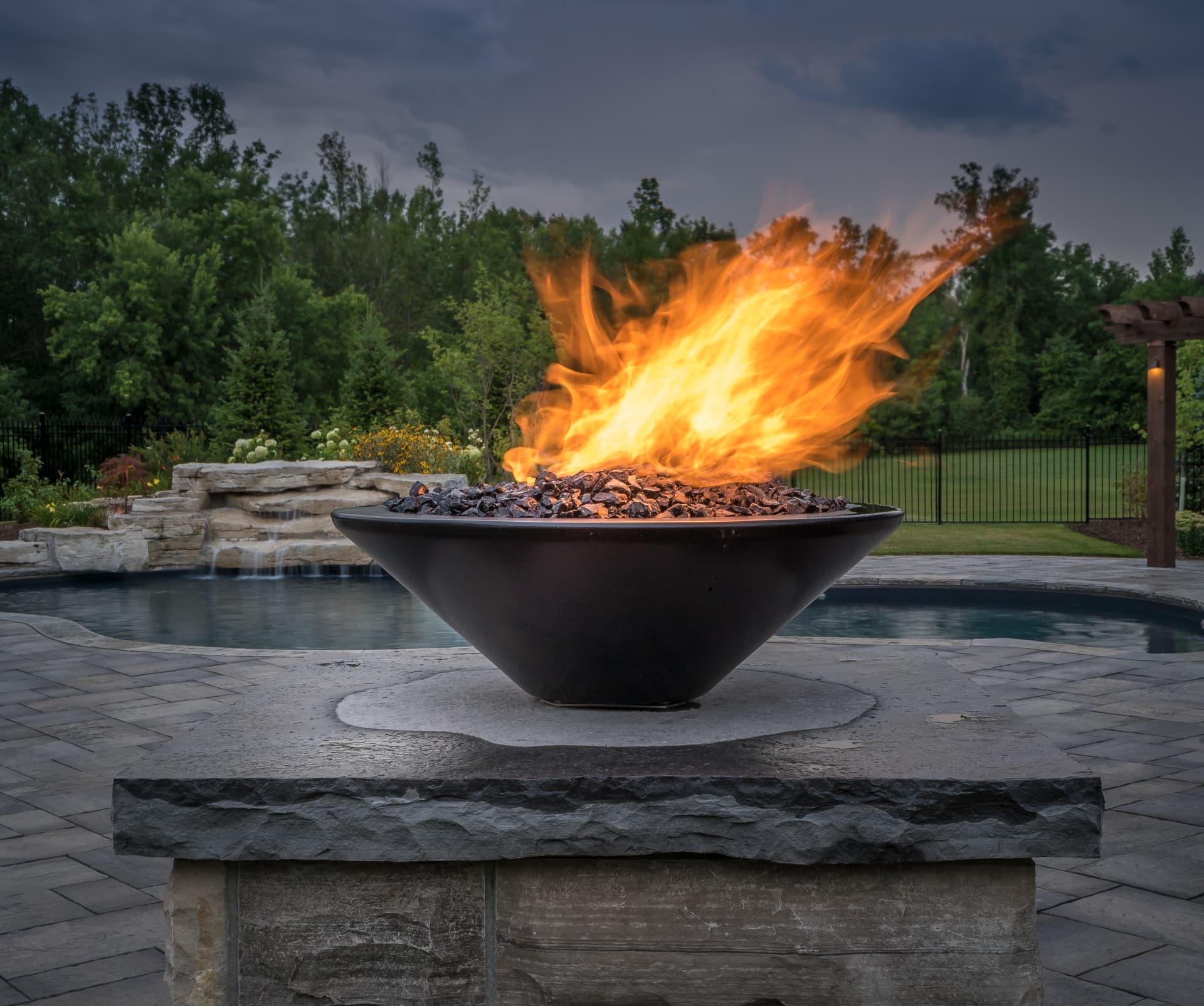 Poolside fire bowl on a natural stone plinth