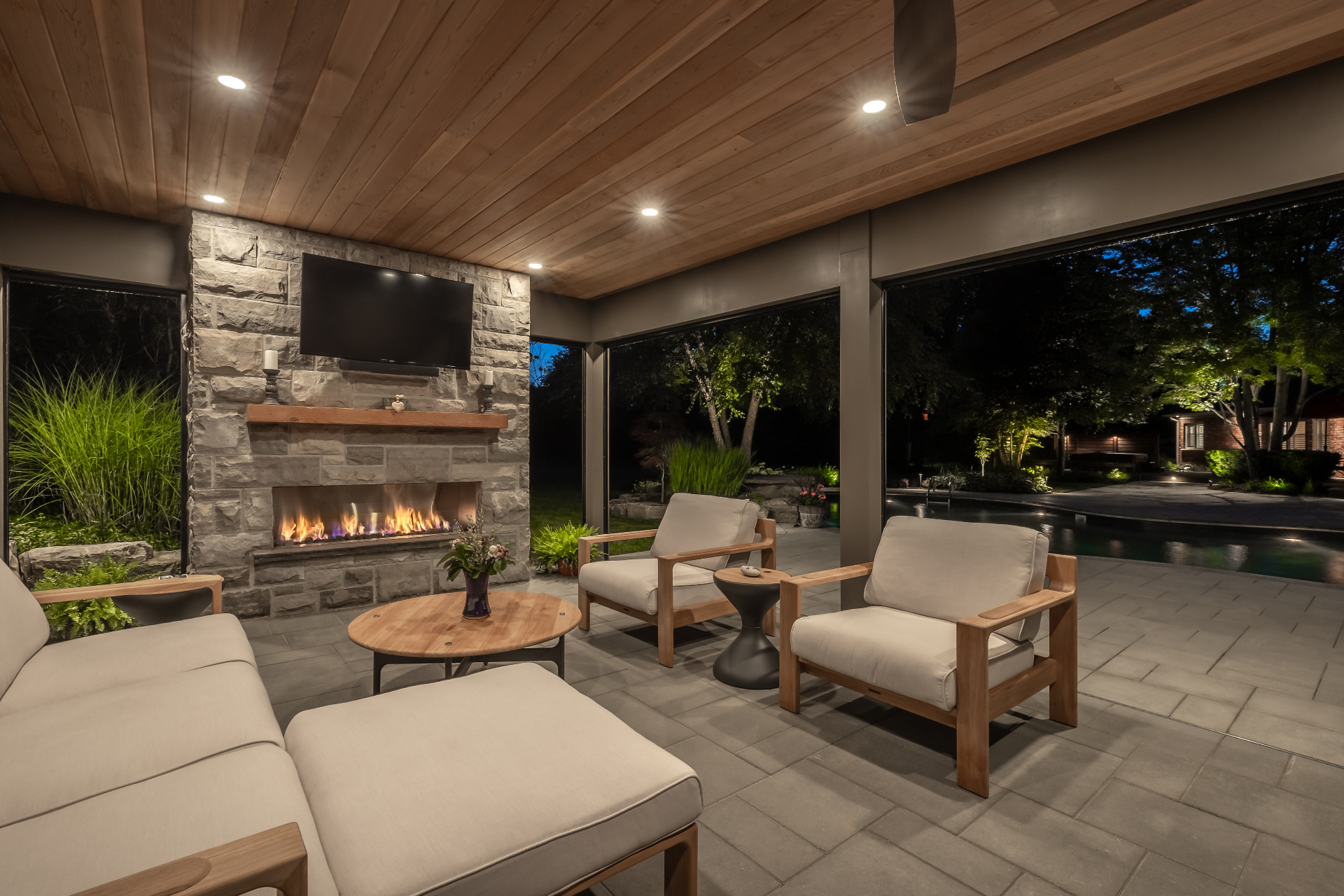 Cabana lounge with fireplace and TV overlooking the pool