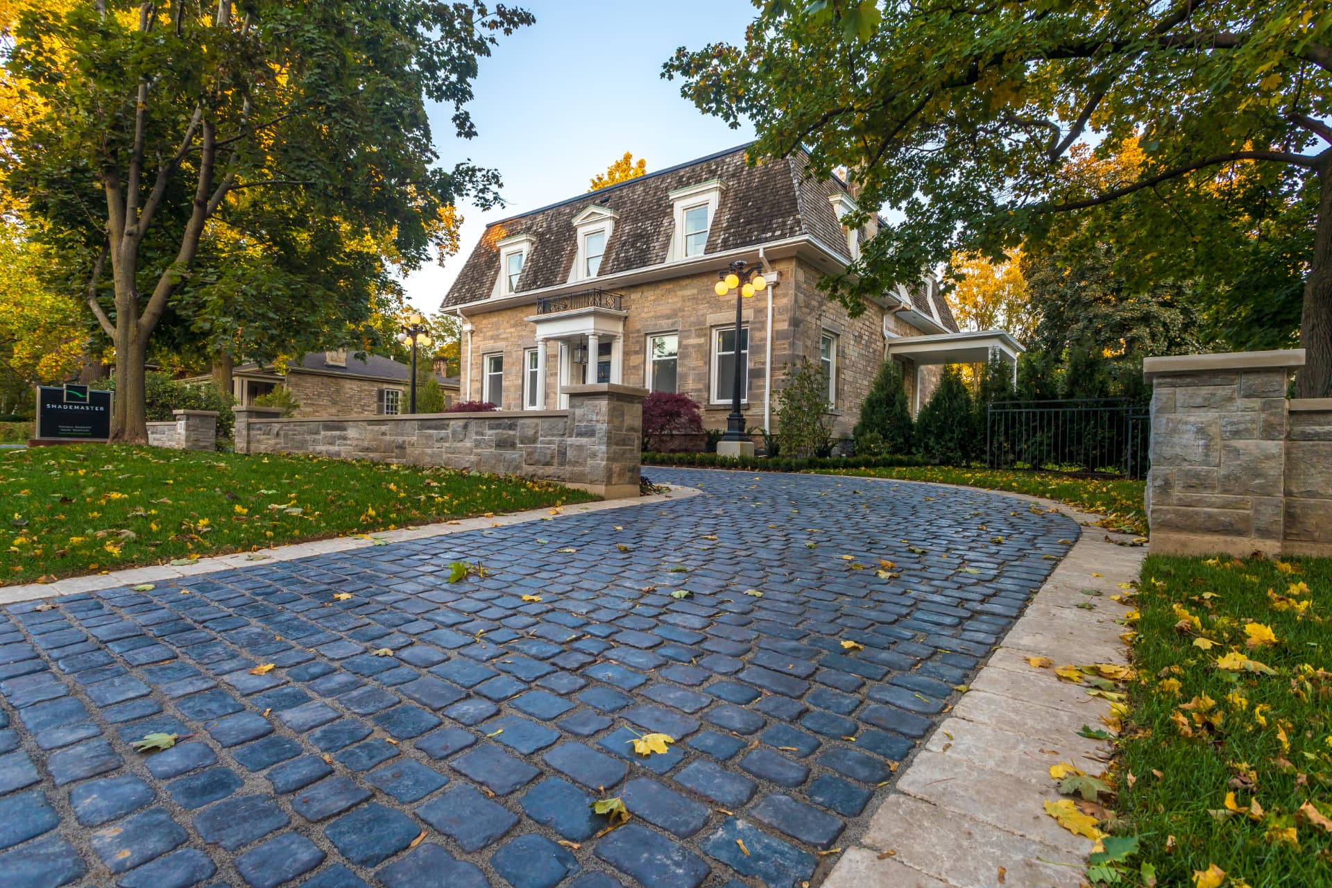 Cobblestone driveway framed by stone pillars and walls