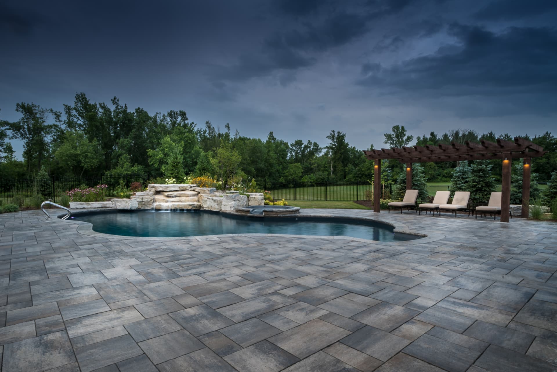 Large-format paver pool patio with pergola lounge