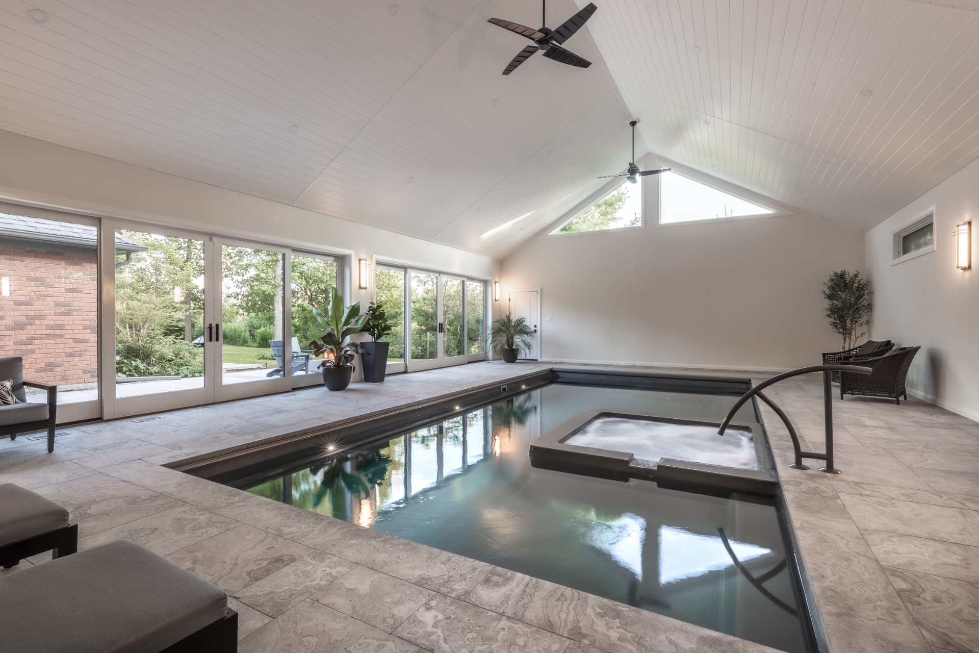 Indoor pool and spa under a vaulted ceiling