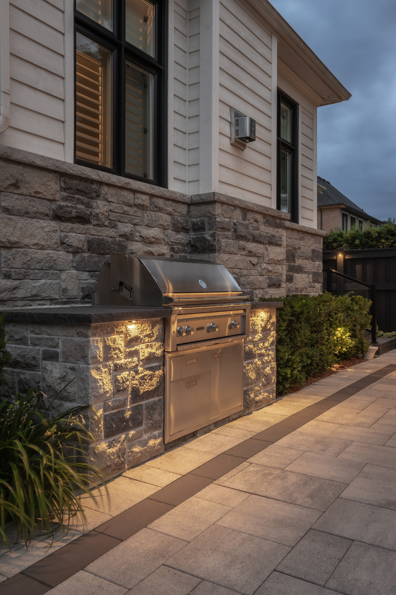 Stone-clad built-in grill with integrated lighting