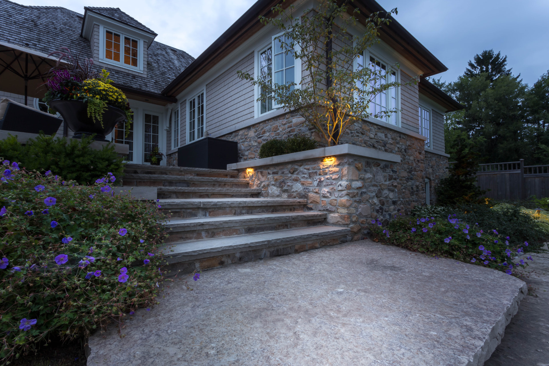 Lit natural stone steps framed by perennial borders