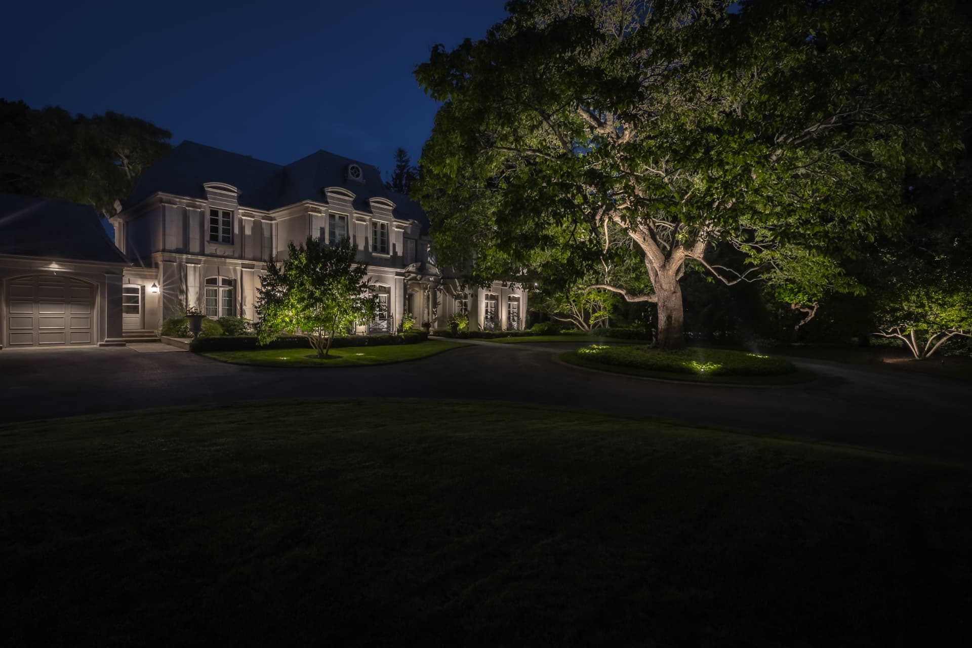 Architectural uplighting on the estate facade and mature trees